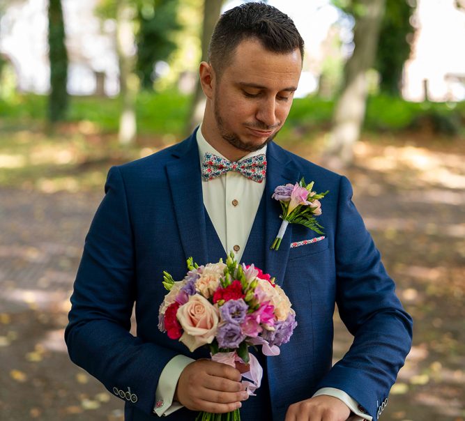 le marié regarde sa montre en attendant la mariée pour le first look