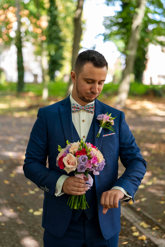 le marié regarde sa montre en attendant la mariée pour le first look