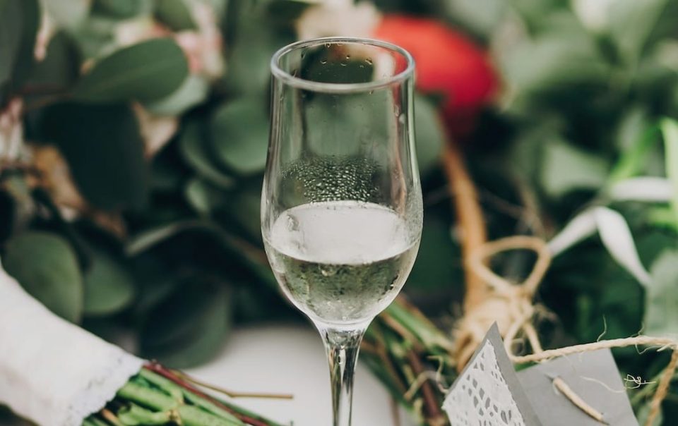 phot d'une coupe de champagne posés sur une table dresses avec des fleurs et plantes