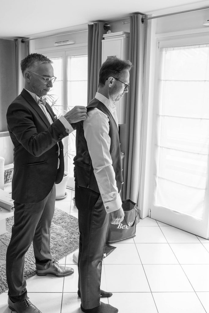 préparation marié mariage Mélanie et Mickael, son témoin ajuste son costume