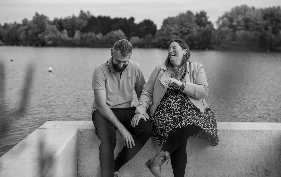 photographe couple haut de france couple qui rie spontanément assis au bord d'un lac