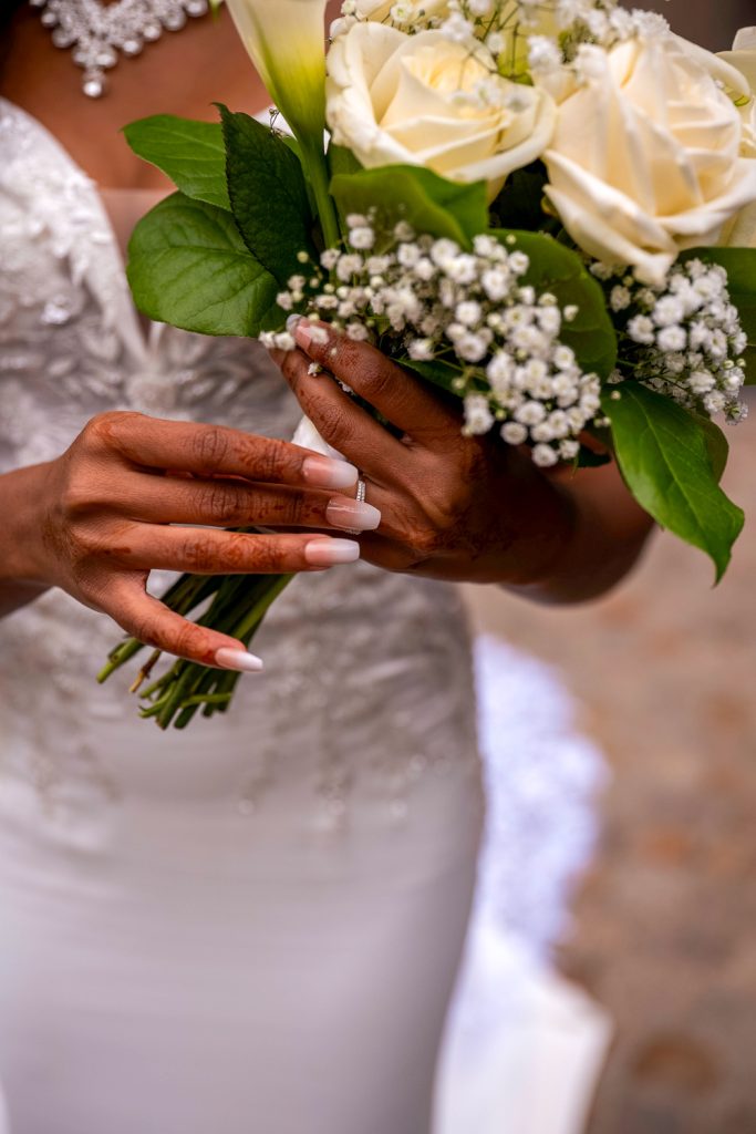 photo en plongée de la robe de la mariée contrée avec son bouquet