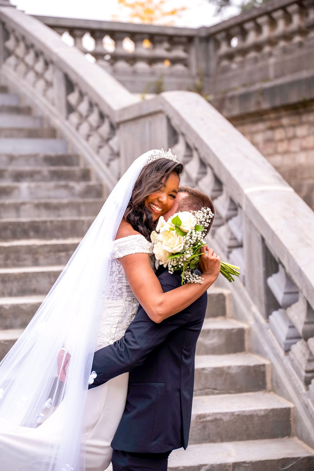 mariée qui saute dans les bras du marié en riant