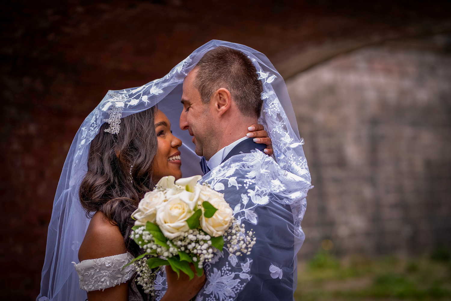 photo couple avec le voile de la mariés sur leur tête