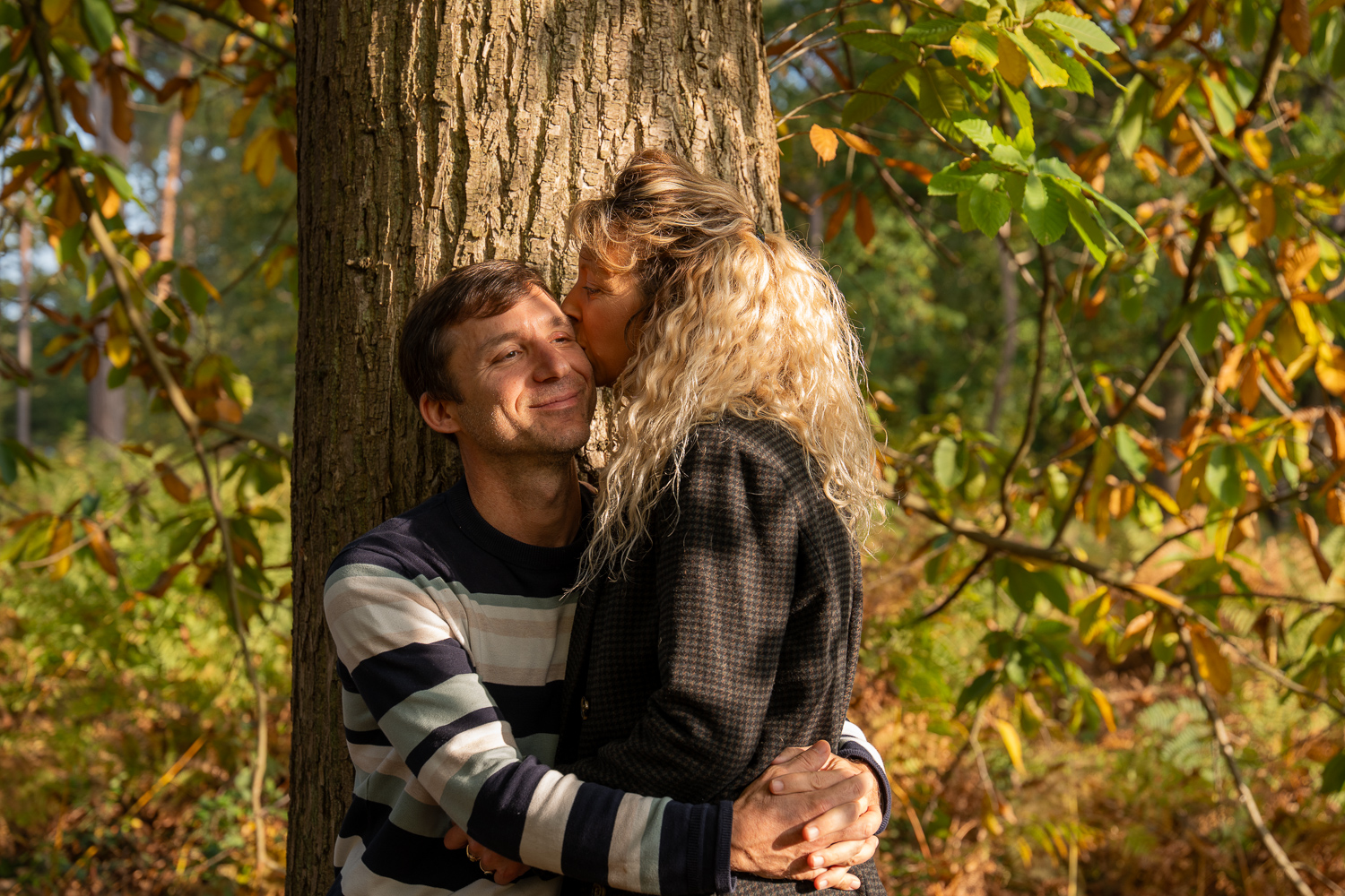 photo couple foret lumière naturelle exterieur foret enlacé contre un arbre