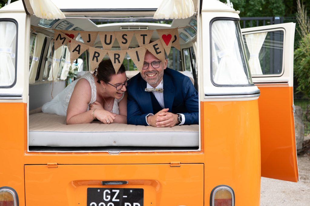 Mélanie et Mickael dans leur van vintage just married et qui rient dans un parc à Lesquin