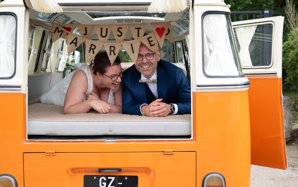 Mélanie et Mickael dans leur van vintage just married et qui rient dans un parc à Lesquin