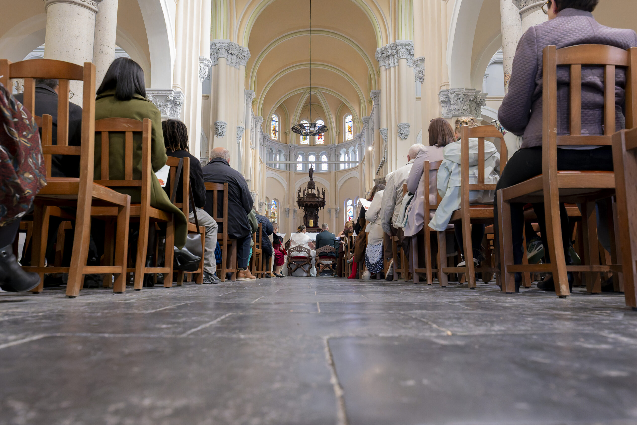 vue de la nef de l'eglise avec au fond les mariés et sur le côté les invités