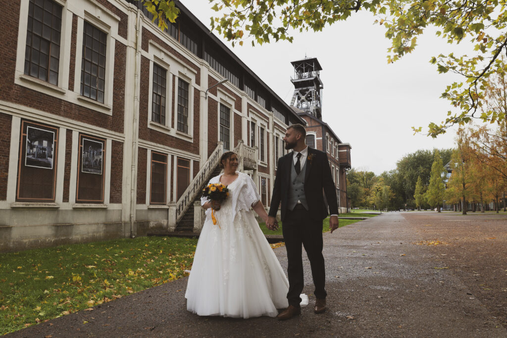 photographe mariage haut de france lens couple marié dans un site minier qui marchent main dans la main en se regardant
