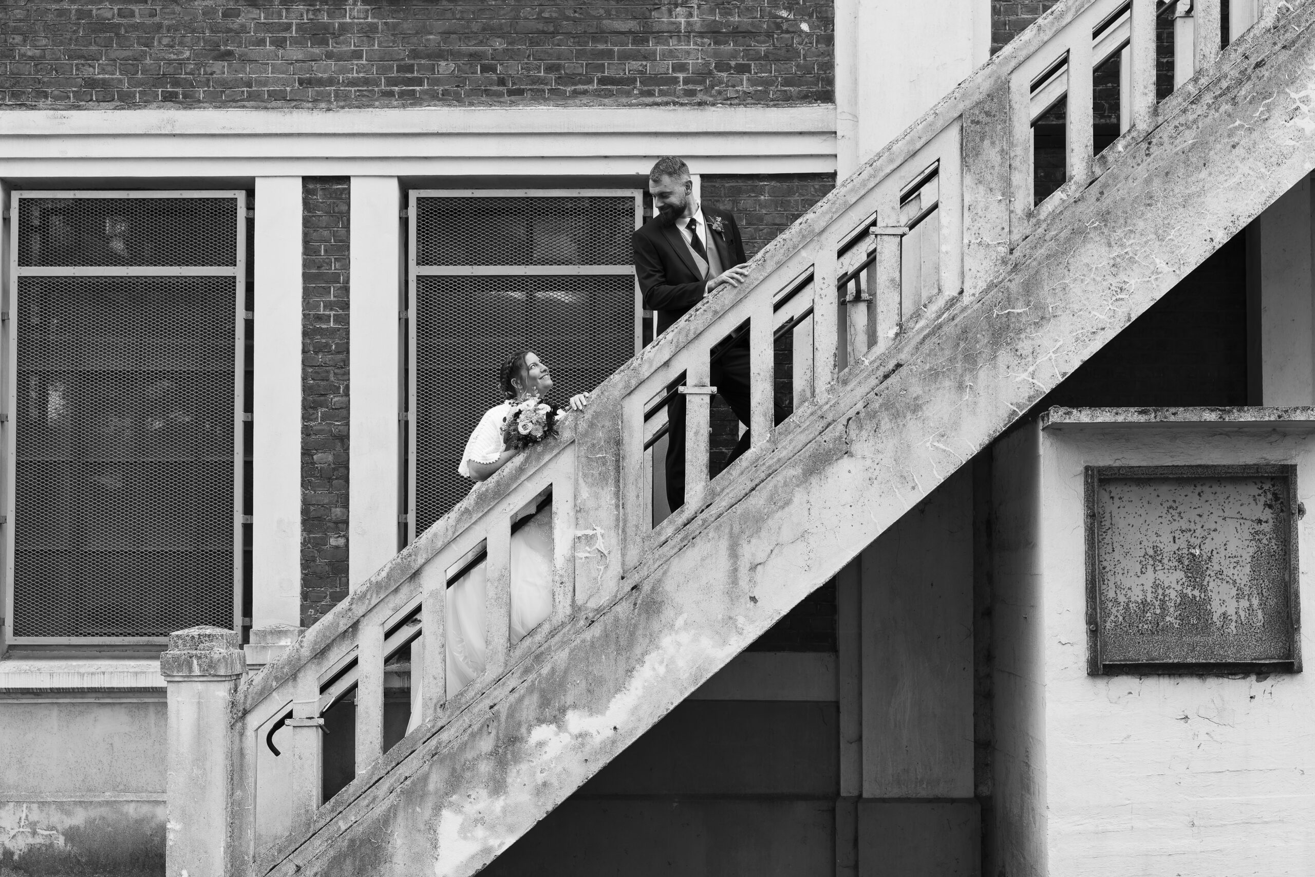 photo de couple marié dans un site minier dans un escalier qui se regardent