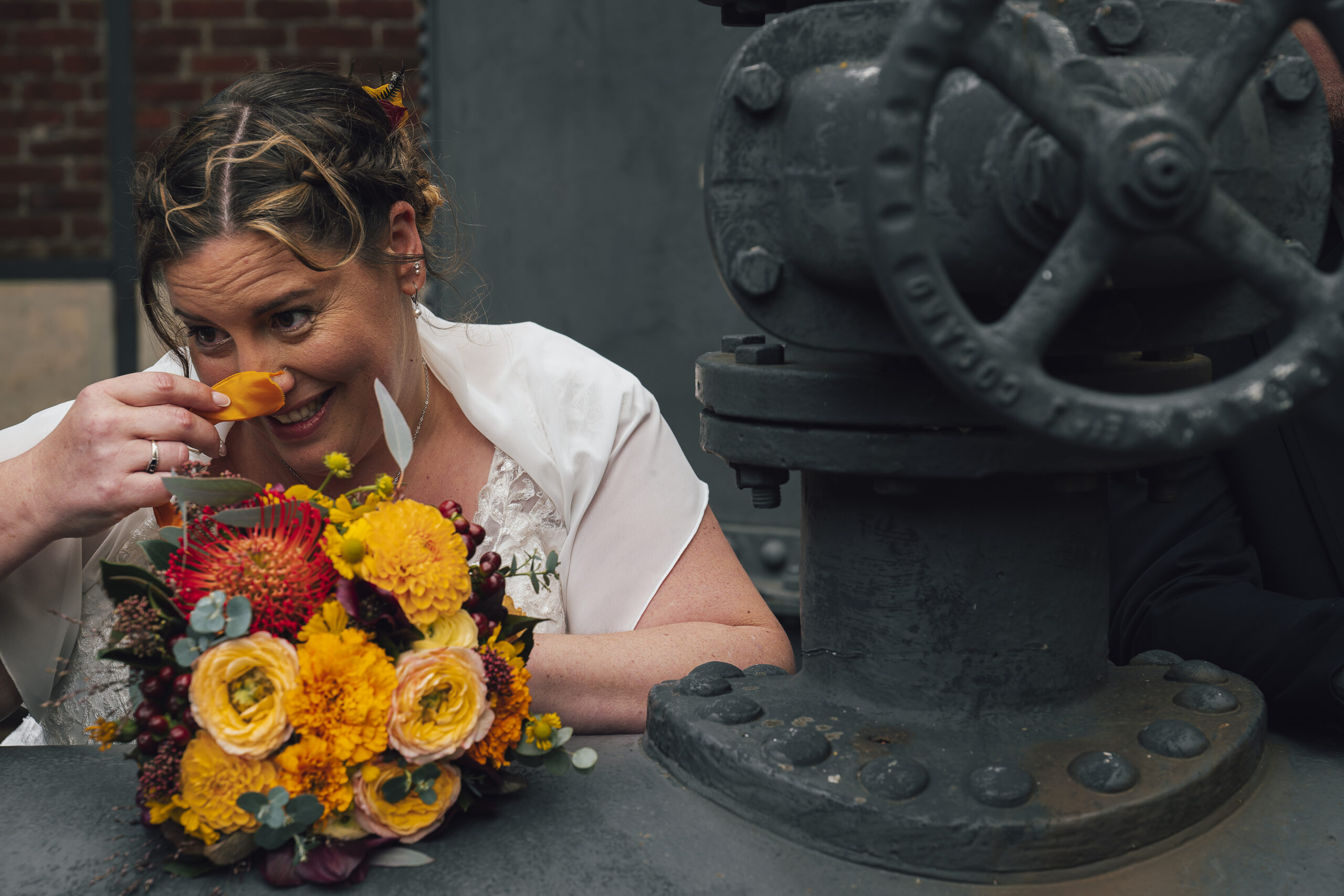 photo de couple marié dans un site minier,mariée qui joue avec les fleurs de son bouquet
