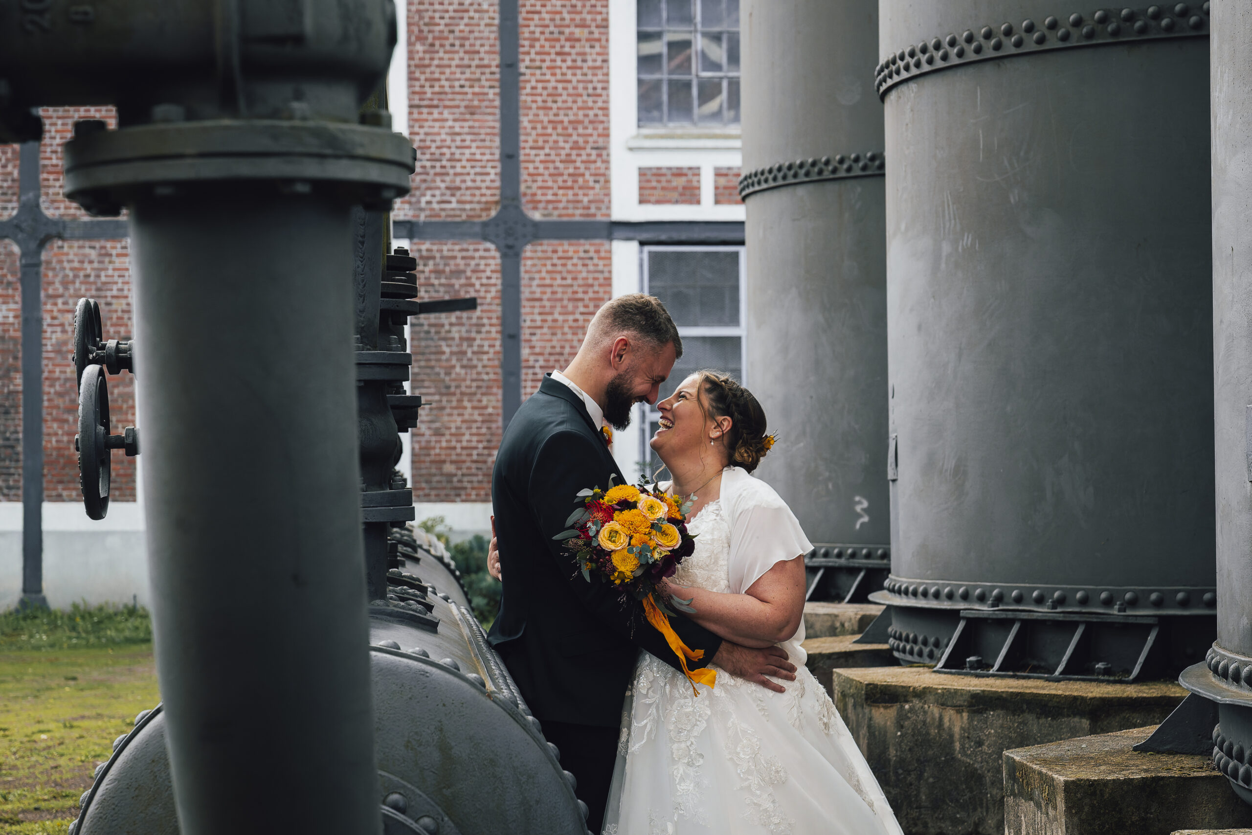 photo de couple marié dans un site minier, pres des machines mariés complices