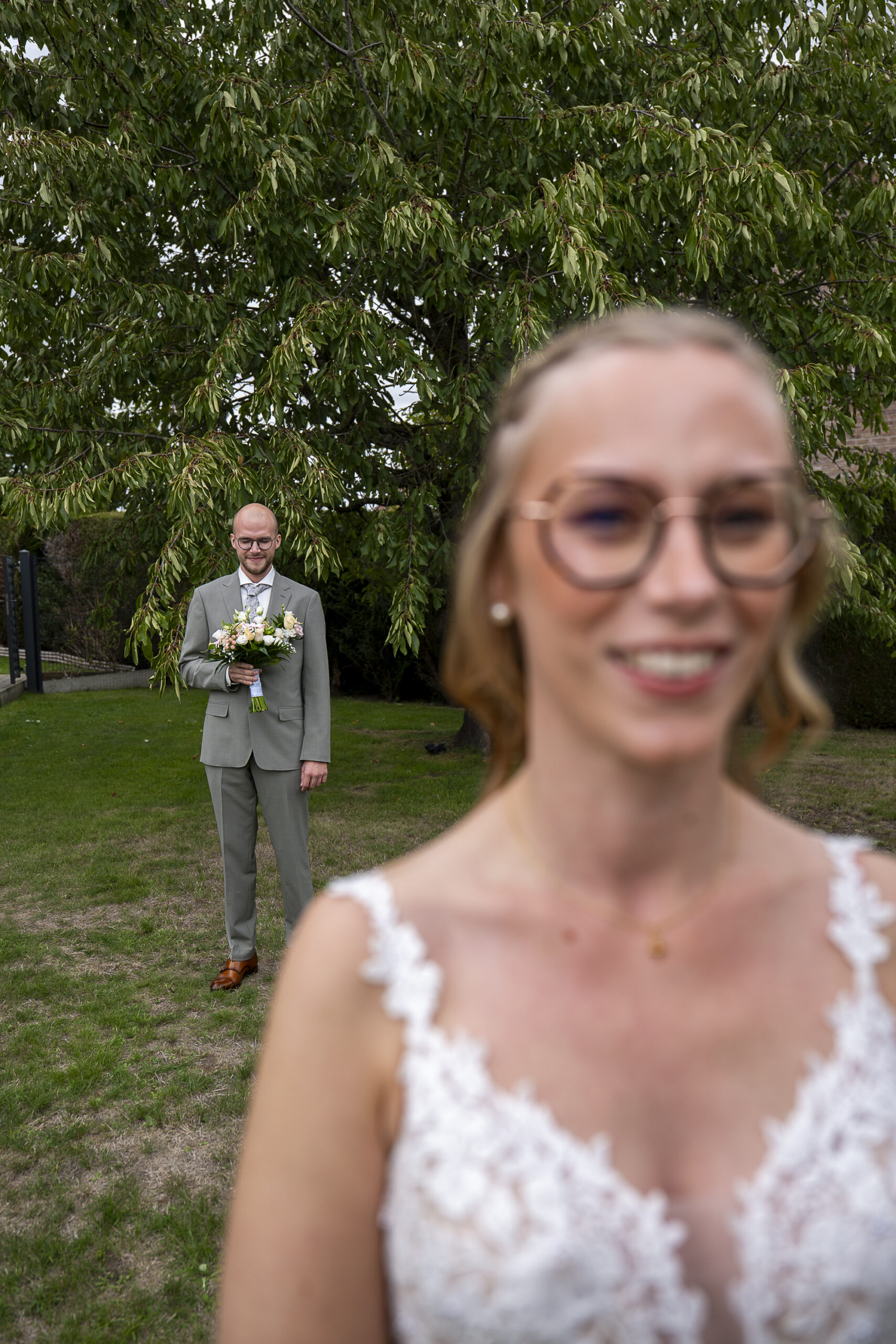 la mariée au premier plan, le marié à l'arrière plan avant le first look
