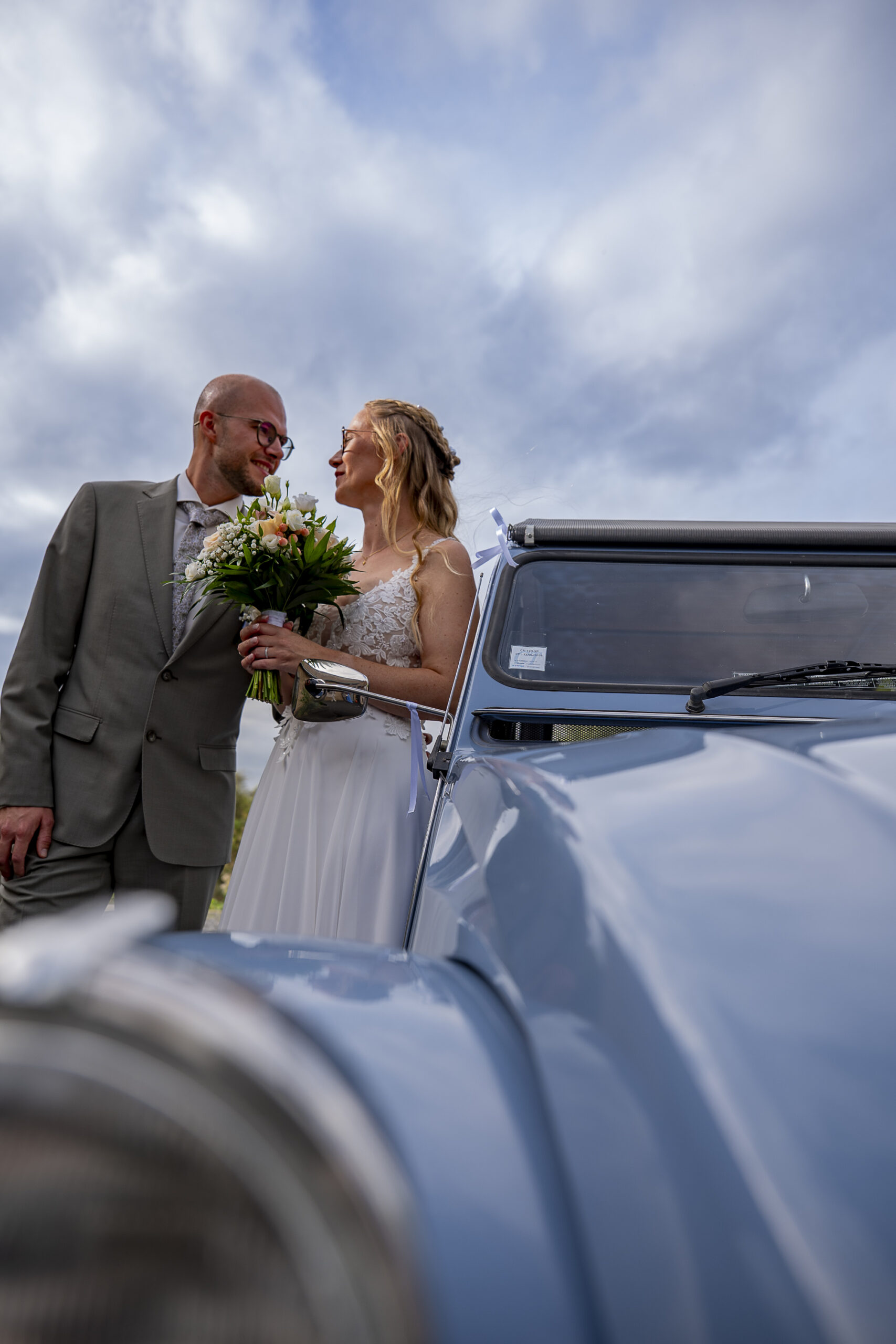 les mariés qui se regardent à cote de la voiture 2CV
